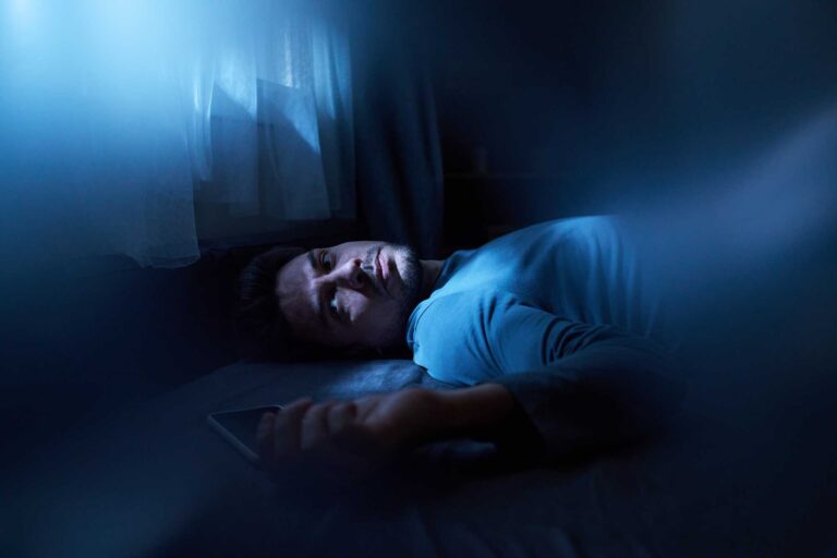Thrive Mind & Wellness Center | Man with insomnia lies awake at night.